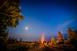 A group of people around a large bonfire.